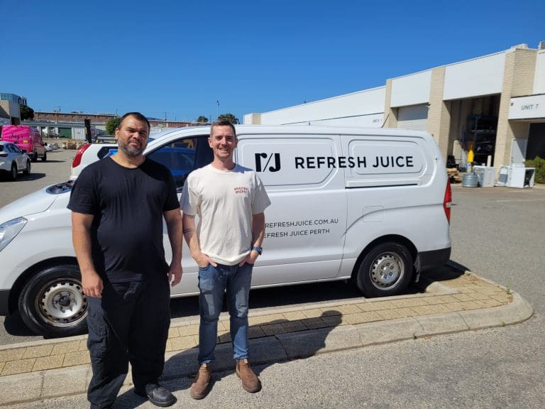 2 men standing in front of van